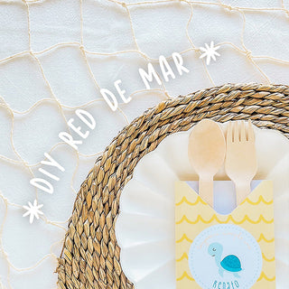 Red de mar decorativa con vajilla y papelería para una celebración de temática marina