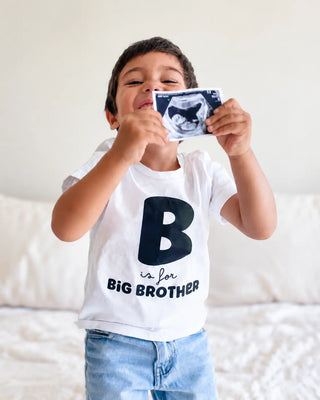 Niño anunciando que será hermano mayor con ecografía y polera personalizada