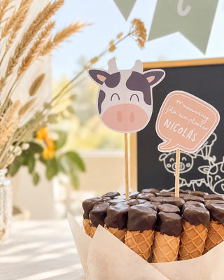 Mesa de cumpleaños infantil con torta y toppers personalizados de animales